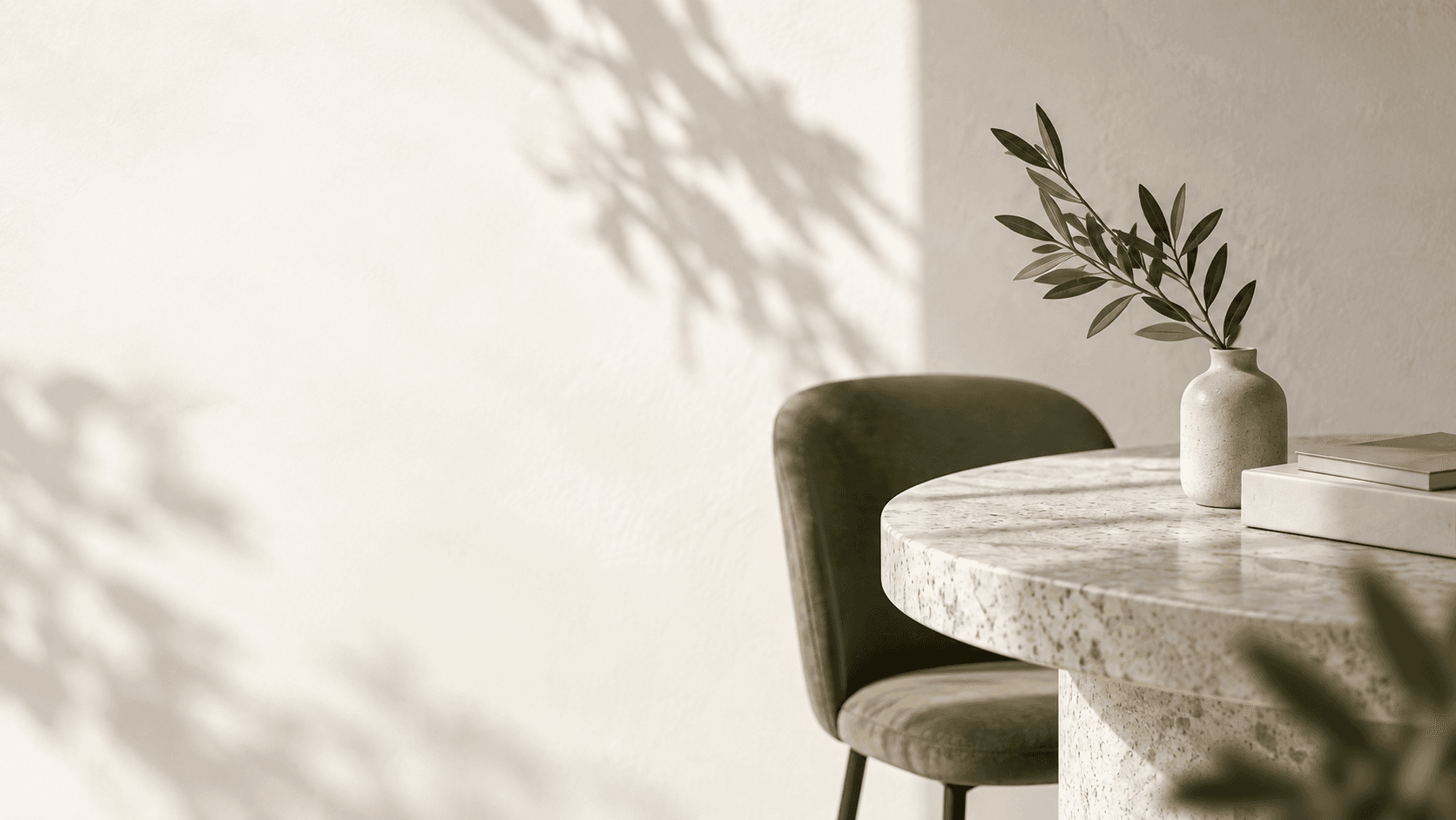 Rustige werkplek met een ronde natuurstenen tafel, olijftak en groene stoel